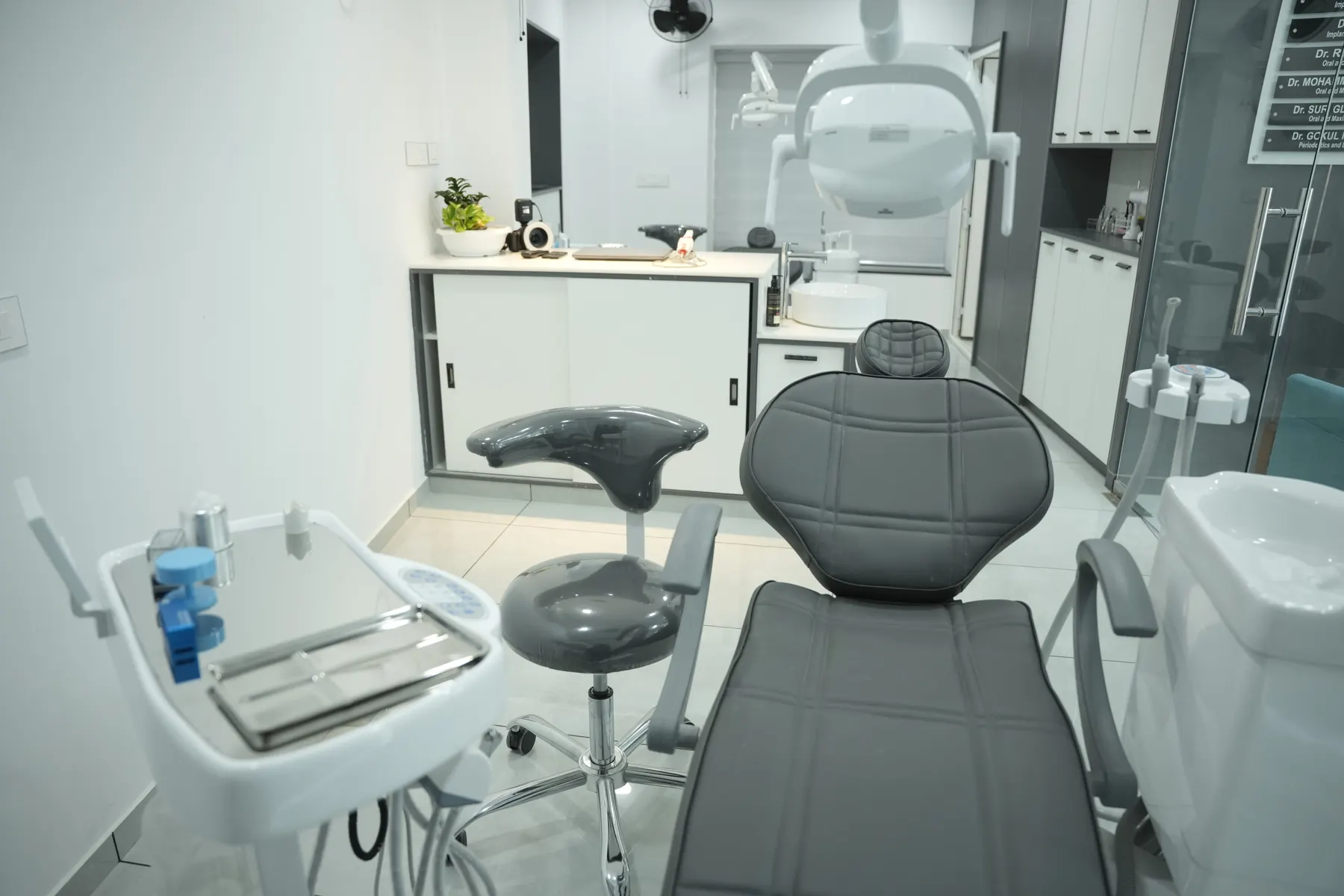 Dental chair and instrument tray in a treatment room at Dental Craft Vanchiyoor